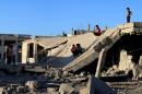 Syrian children slide down rubble of destroyed a building in the rebel-held city of Daraa on September 12, 2016