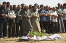 Syrian mourners pray over the body of a member of the Free Syrian Army in Homs