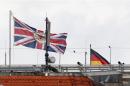 A Union Jack flag flutters on the roof of the British embassy next to a German national flag in Berlin