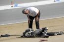 In this Sunday, July 19, 2015, photo, a race official looks at Spanish rider Bernat Martinez after a chain reaction crash on the first lap of a World Superbike race at Mazda Raceway at Laguna Seca in Monterey, Calif. Two Spanish racers were killed in the crash. Race organizers MotoAmerica identified the dead as 35-year-old Bernat Martinez and 27-year-old Daniel Rivas Fernandez. Both were taken to hospitals, where they later died. (Nic Coury/Monterey County Weekly via AP) MANDATORY CREDIT FOR PAPER AND PHOTOGRAPHER. MONTEREY HERALD OUT , SALINAS CALIFORNIAN OUT , SANTA CRUZ SENTINEL OUT , SAN JOSE MERCURY OUT , LOCAL TV OUT