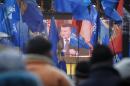 Supporters of Ukrainian President Viktor Yanukovich watch a broadcast of his news conference as they attend a rally in Kiev