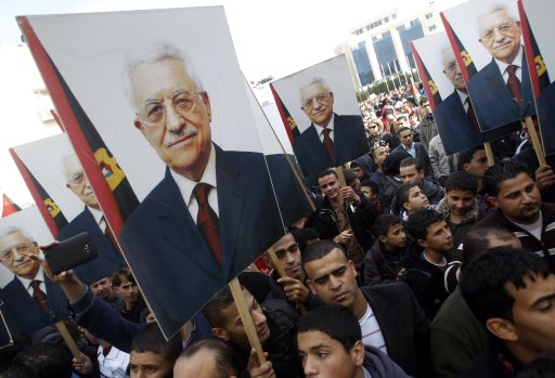 Palestinians hold placards depicting President Abbas' during a rally in support of his efforts to secure a diplomatic upgrade at the United Nations, in Ramallah