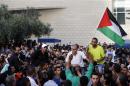 An Israeli Arab man holds a Palestinian flag as he is carried by supporters after his sentencing outside court in Haifa