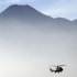 An Indonesian helicopter carrying the bodies of victims of Wednesday's plane crash flies through Bogor, in West Java, Indonesia. Clearer weather finally allowed Indonesian helicopters to land Saturday and retrieve some remains of the 45 people aboard a Russian-made plane that crashed into the volcano during a demonstration flight. (AP Photo/Achmad Ibrahim)