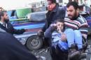 In this image taken from video obtained from the Shaam News Network, which has been authenticated based on its contents and other AP reporting, a man carries a child out of a building as another man shedding blood on his face evacuates himself after a blast at the building in Aleppo, Syria, Thursday, Dec. 19, 2013. In northern Syria, government war planes have bombed rebel-held districts of Aleppo for the fifth straight day, leveling apartment buildings, flooding hospitals with casualties in attacks that have so far killed nearly 200 people, activists said. (AP Photo/Shaam News Network via AP Video)