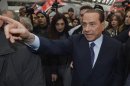 Former Italian PM Berlusconi gestures as he arrives at Milan train station