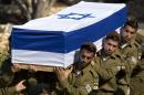 Israeli soldiers carry the coffin of Staff Sgt. Moshe Melako, 20, during his funeral at the Mount Herzel military cemetery in Jerusalem, Monday, July 21, 2014. Melako was one of 13 soldiers killed in several separate incidents in Shijaiyah on Sunday, as Israel-Hamas fighting exacted a steep price, killing scores of Palestinians and more than a dozen Israeli soldiers. In Israel, a country where military service is mandatory for most citizens, military losses are considered every bit as tragic as civilian ones. (AP Photo/Sebastian Scheiner)