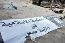 A banner belonging to the Islamic court of the Islamic State is seen on the ground after forces loyal to Syria's President Bashar al-Assad recaptured Palmyra city, in Homs Governorate