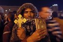 An anti-Mursi protester holds a Cross and a Koran at Tahrir Square in Cairo