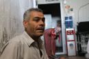 Syrian refugee Mohammed Said Amin, 48, sits in a former prison cell that as been converted into iving quarters for refugees