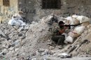 A Free Syrian Army fighter holds his rifle during clashes with Syrian Army soldiers in Salah al- Din neighbourhood in central Aleppo