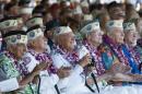 Pearl Harbor survivors watch a vintage WWII airplane fly over Pearl Harbor at the ceremony commemorating the 72nd anniversary of the attack on Pearl Harbor, Saturday, Dec. 7, 2013, in Honolulu. (AP Photo/Marco Garcia)