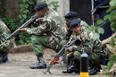 Armed Kenyan policemen take cover outside the Westgate mall in Nairobi on September 23, 2013