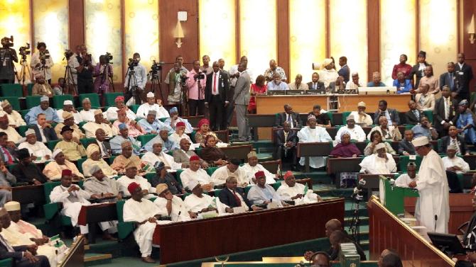 Nigerian President Muhammadu Buhari (R) speaks to members of the National Assembly after submitting his record budget for 2016 in Abuja, on December 22, 2015