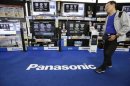 A man walks past Panasonic Corp's Viera televisions displayed at an electronics store in Tokyo