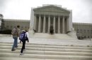 Tourists walk in front of the Supreme Court building in Washington