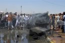 People gather at the site of a suicide car bomb attack in the city of Samarra