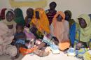Women and children sit at the army headquaters after being rescued from Boko Haram camps in Maiduguri, Borno State, in northeastern Nigeria, on July 30, 2015
