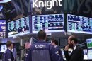 Traders work at the Knight Capital kiosk on the floor of the New York Stock Exchange