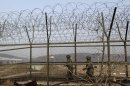 South Korean army soldiers patrol along a barbed-wire fence at the Imjingak Pavilion near the border village of Panmunjom, which has separated the two Koreas since the Korean War, in Paju, north of Seoul, South Korea, Wednesday, March 6, 2013. North Korea's military is vowing to cancel the 1953 cease-fire that ended the Korean War, straining already frayed ties between Washington and Pyongyang as the United Nations moves to impose punishing sanctions over the North's recent nuclear test. (AP Photo/Lee Jin-man)