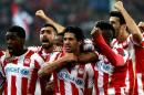 Olympiakos' Argentinian midfielder Alejandro Dominguez (C) celebrates with teammates after scoring a goal during the round of 16 Champions League football match Olympiakos vs Manchester United at Karaiskaki Stadium in Athens on February 25, 2014