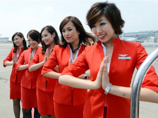 Air Asia Japan cabin attendants greet journalists at the Narita International airport, on July 19, 2012