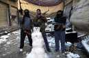Members of the Free Syrian Army pose with their weapons and a snowman at the Jouret al Shayah area in Homs