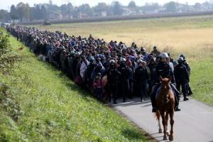 A mounted policeman leads a group of migrants near&nbsp;&hellip;