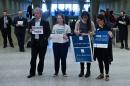 Activists and chauffeurs wait to greet travelers at the international arrivals hall at Washington Dulles International Airport on February 6, 2017 in Virginia