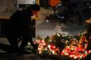 Mourners placed flowers and candles at the site where a truck rampaged through a Berlin Christmas market killing 12, a flags flew at half-mast