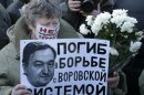 A woman holds a placard with a portrait of Sergei Magnitsky during an unauthorised rally in central Moscow