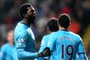Tottenham Hotspur's Emmanuel Adebayor, left, celebrates his goal with his teammates during their English Premier League soccer match against Newcastle United at St James' Park, Newcastle, England, Wednesday, Feb. 12, 2014. (AP Photo/Scott Heppell)