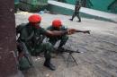 Military police gesture near state broadcaster RTNC as gunfire erupted on December 30, 2013 at the premises of the broadcaster in Kinshasa