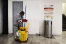 An employee cleans next a poster on the prevention of Ebola at Benito Juarez International airport in Mexico City