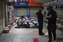 Policemen check unclaimed luggage at a square outside the Kunming railway station after a knife attack, in Kunming