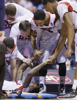 Louisville players talk to guard Kevin Ware after his compound fracture. (AP)