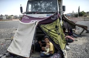 Syrian refugees sit in their makeshift shelter near &hellip;