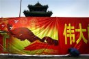 A worker installs a propaganda banner outside the 700-year-old Dongyue Temple in central Beijing
