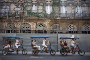 Tourists ride in pedicabs in Havana