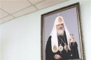 Priest Innokenty Nilov cleans a portrait of Russian Orthodox Patriarch Kirill during preparations to celebrate Orthodox Christmas at the Svyato-Uspensky Orthodox monastery in Russia's Siberian city of Krasnoyarsk