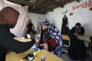 An Afghan woman puts her thumb print on her voter card at a registration centre in Kabul