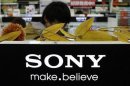 A man stands behind Sony Corp's logo at an electronics store in Tokyo