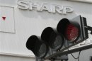 Sharp's logo is seen behind a traffic sign outside an electronics shop in Tokyo