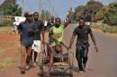 People in the Central African Republic carry a wounded man in a trolley after an attack by anti-Balaka fighters on January 22, 2014 in the Pk 13 district, north of Bangui