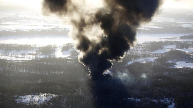 Smoke rises from the scene of a train derailment Thursday, March 5, 2015, near Galena, Ill. A BNSF Railway freight train loaded with crude oil derailed around 1:20 p.m. in a rural area where the Galena River meets the Mississippi, said Jo Daviess County Sheriff's Sgt. Mike Moser. (AP Photo/Telegraph Herald, Mike Burley)