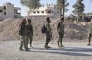 Forces loyal to Syria's President Bashar al-Assad walk in the town of al-Qaryatain, Syria, after they recaptured it