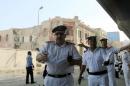 Egyptian security officials gesture at the site of a bomb blast at the Italian Consulate in Cairo