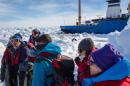 Passengers from the stranded Russian ship MV Akademik Shokalskiy wait for a helicopter from the nearby Chinese icebreaker Xue Long to pick them up on January 2, 2014