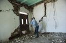 Mynor Fuentes checks his home after it was damaged during an earthquake in San Pedro, Guatemala, Monday, July 7, 2014. A magnitude-6.9 earthquake on the Pacific Coast jolted a wide area of southern Mexico and Central America Monday. (AP Photo/Oliver de Ros)