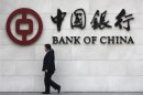 File photo of a woman walking past a sign of Bank of China at its branch in Beijing